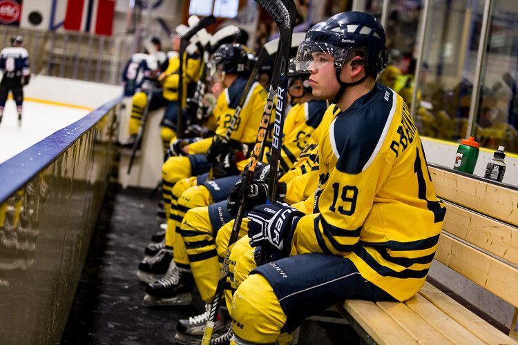 A hockey player sitting on the bench during a game