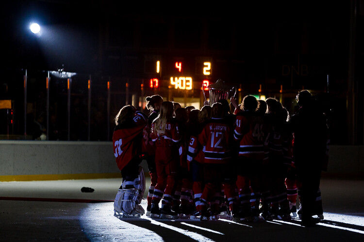 A hockey team celebrates winning the trophy